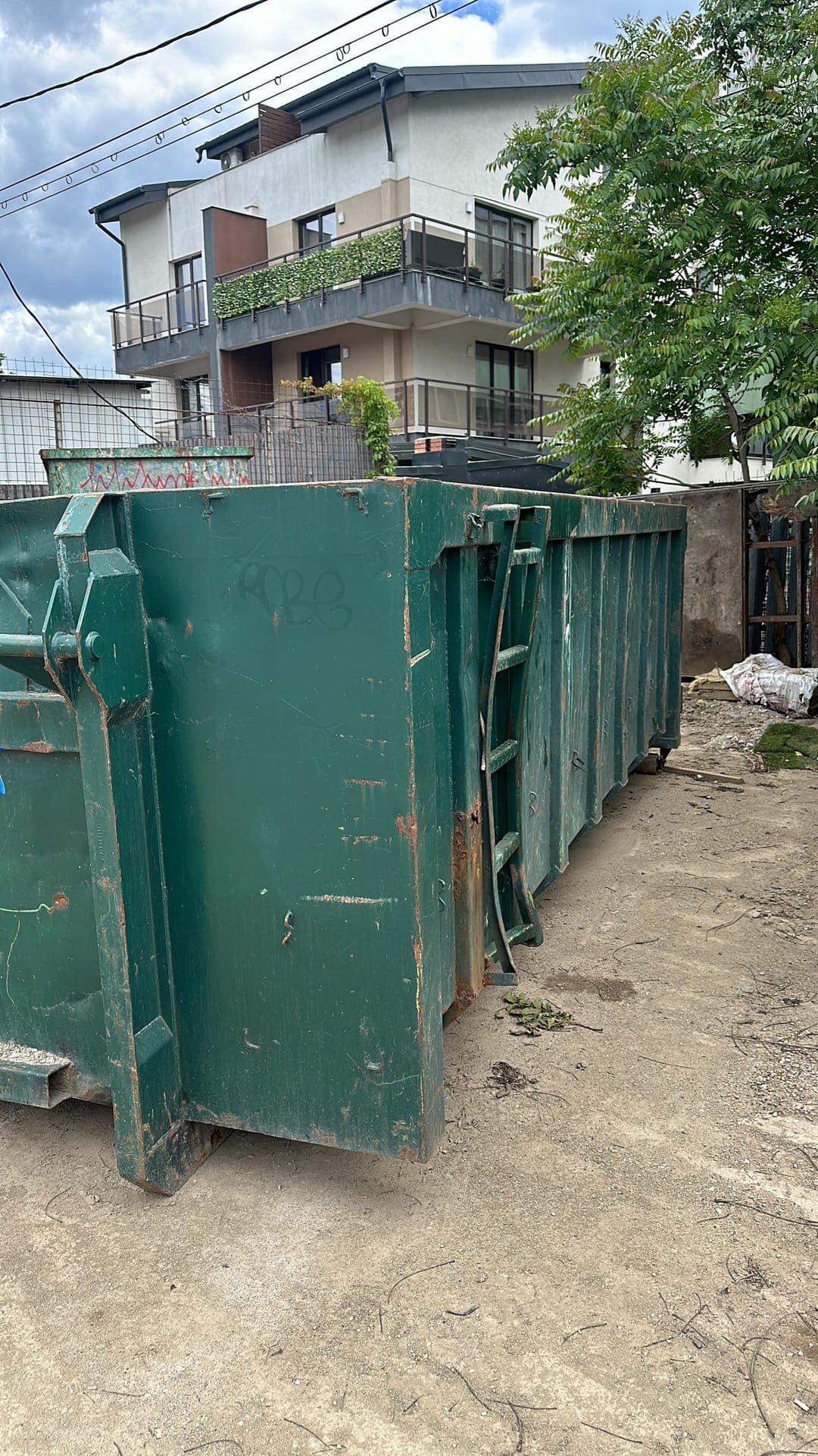 Container moloz de mare capacitate amplasat în fața unei case pentru evacuare deșeuri din renovare