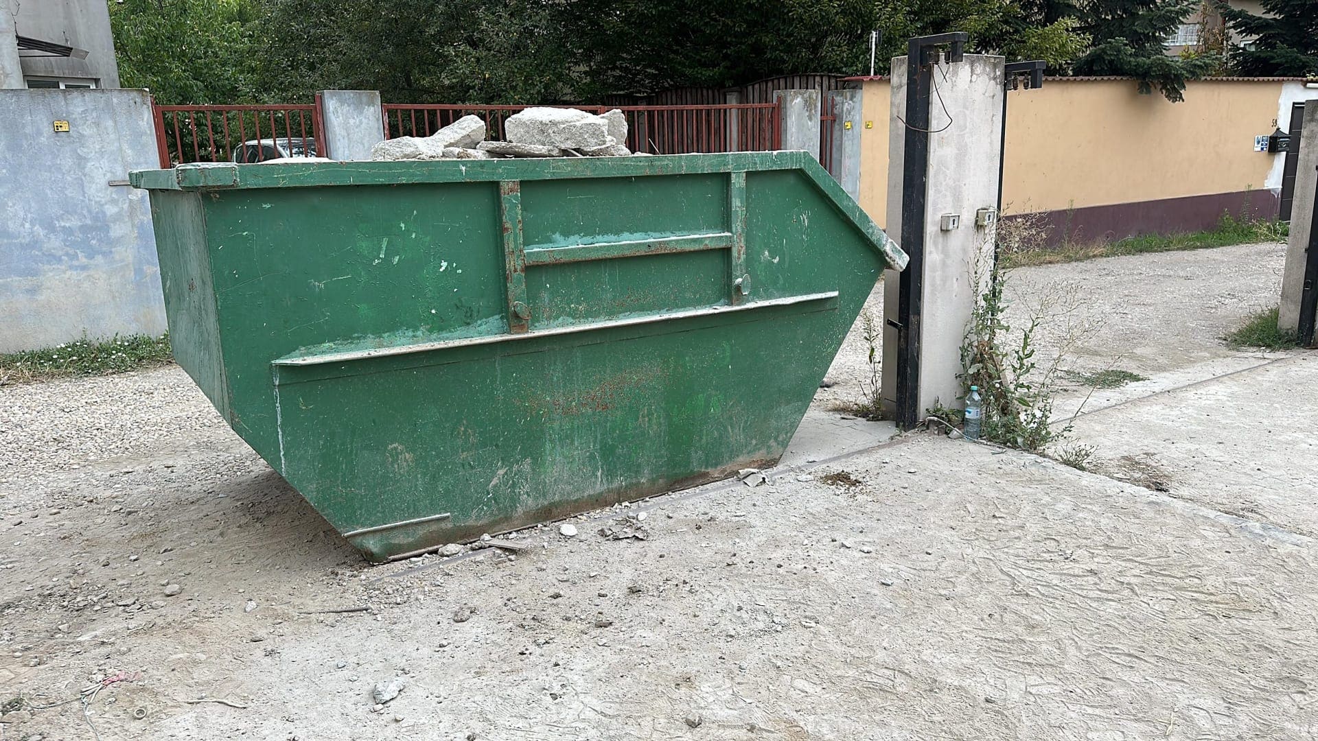 Container moloz încărcat cu beton și cărămidă la un șantier de renovare din București