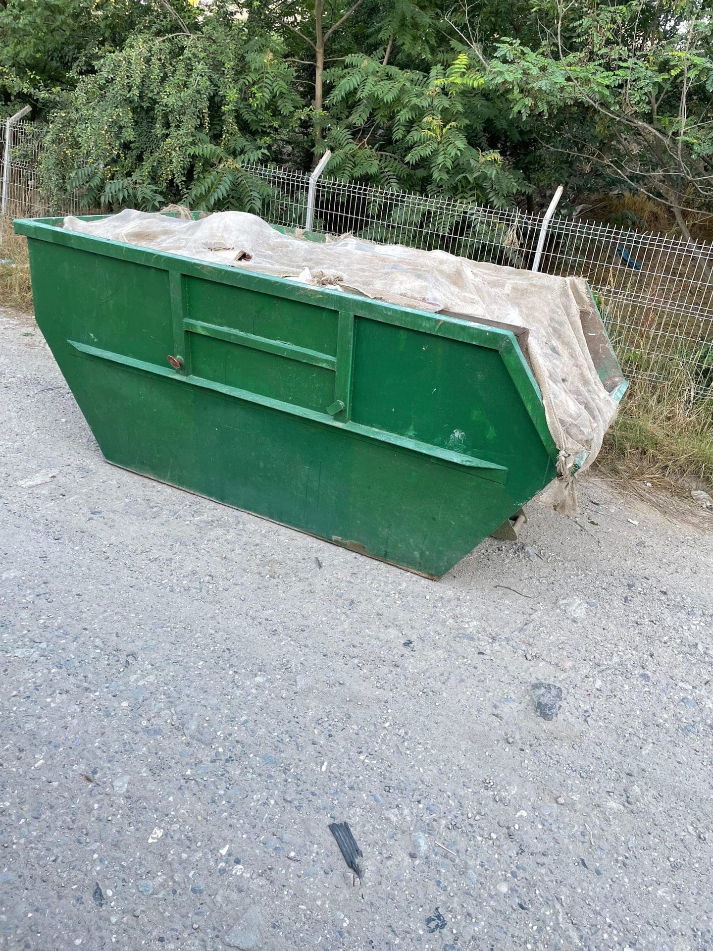 Container moloz acoperit cu prelată, pregătit pentru transport autorizat al deșeurilor